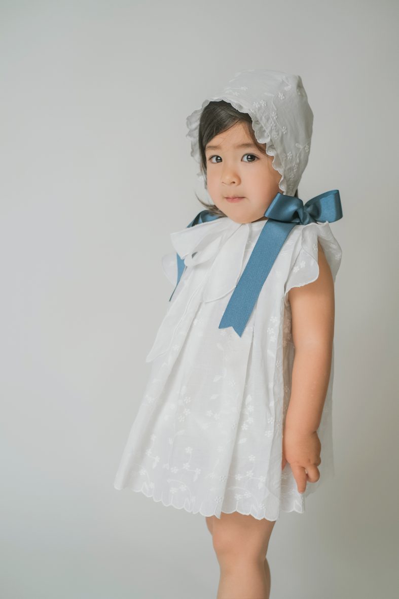 Vestido blanco bordado tablas lazos azul cobalto